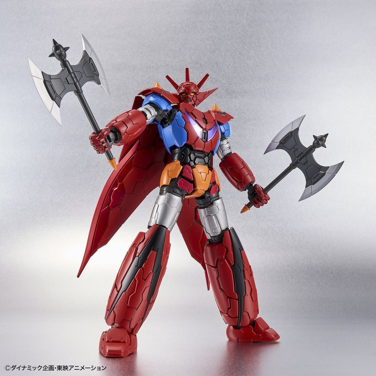 Red, blue, and silver Getter Robo action figure with a cape, holding two large battle axes in a dynamic pose.