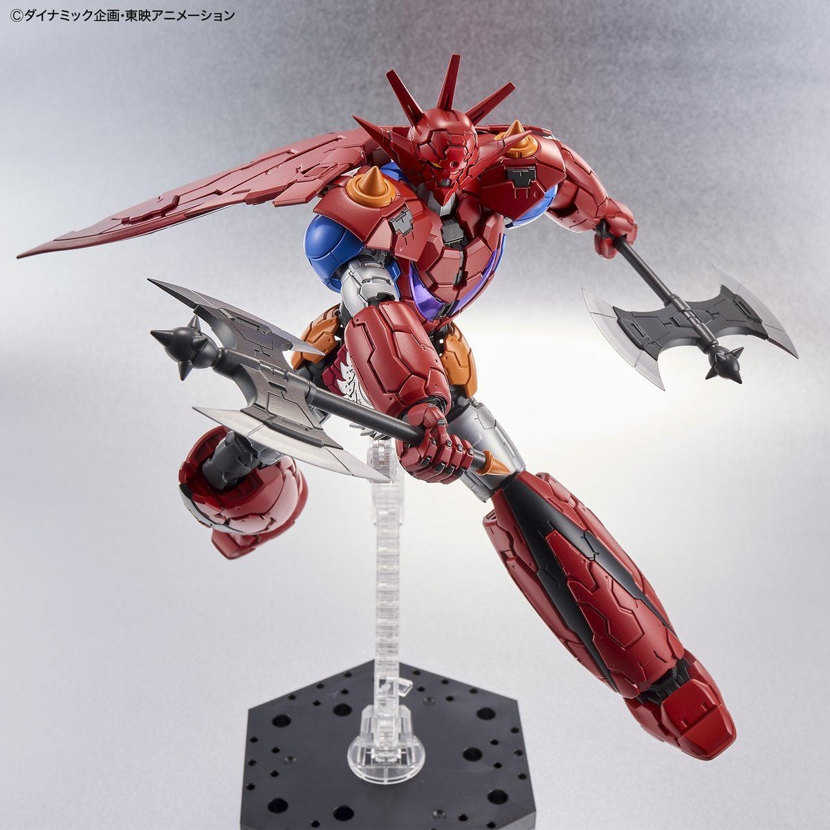 Getter Robo action figure in red and metallic armor, posed mid-air wielding two battle axes on a display stand.