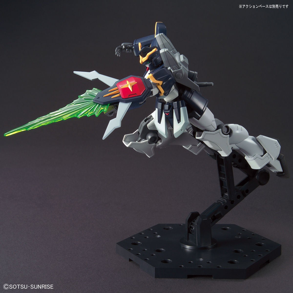 Model kit Bandai Gundam Deathscythe HG 1:144 in posa dinamica con scudo a raggio verde su base espositiva.