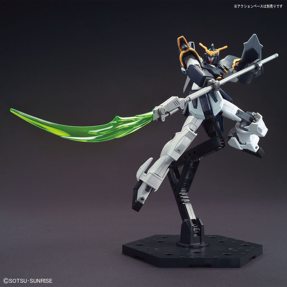 Model kit Bandai Gundam Deathscythe HG 1:144 in posa dinamica con falce laser verde su sfondo grigio.
