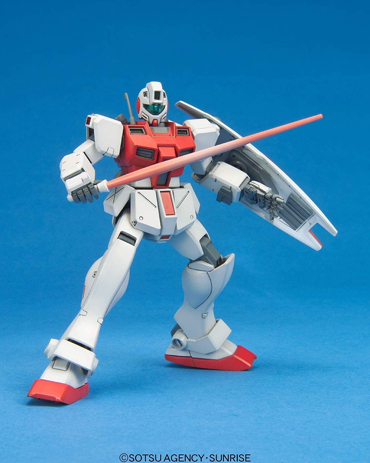 Gundam action figure in white and red, holding a beam saber and shield against a blue background.