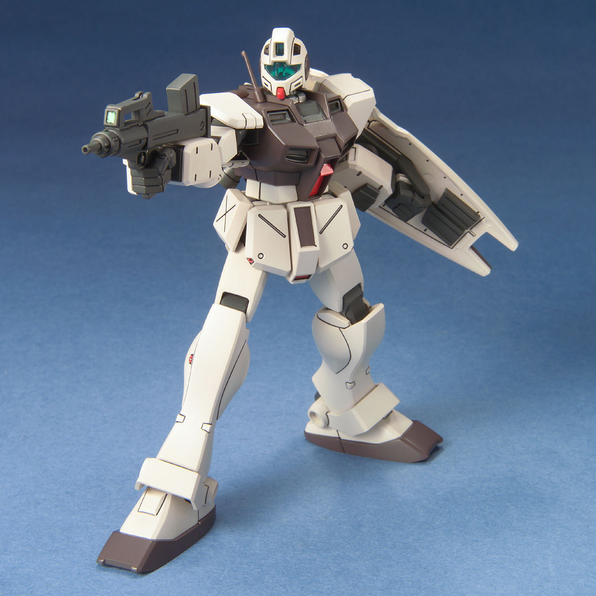 White and dark gray Gundam model kit holding a rifle and shield, posed against a blue background.