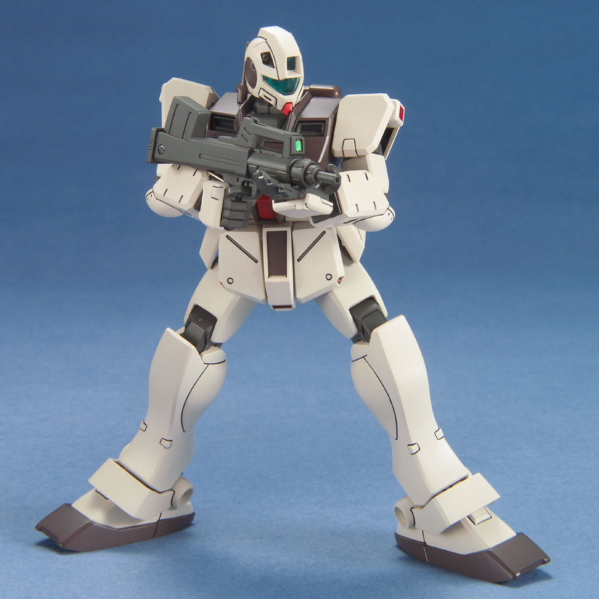 Off-white and gray Gundam model kit standing in a combat pose, holding a rifle against a blue background.
