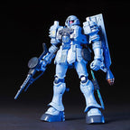 Model kit Bandai HGUC 1:144 EMS-10 Zudah: robot mecha blu con fucile, in posa su sfondo nero.