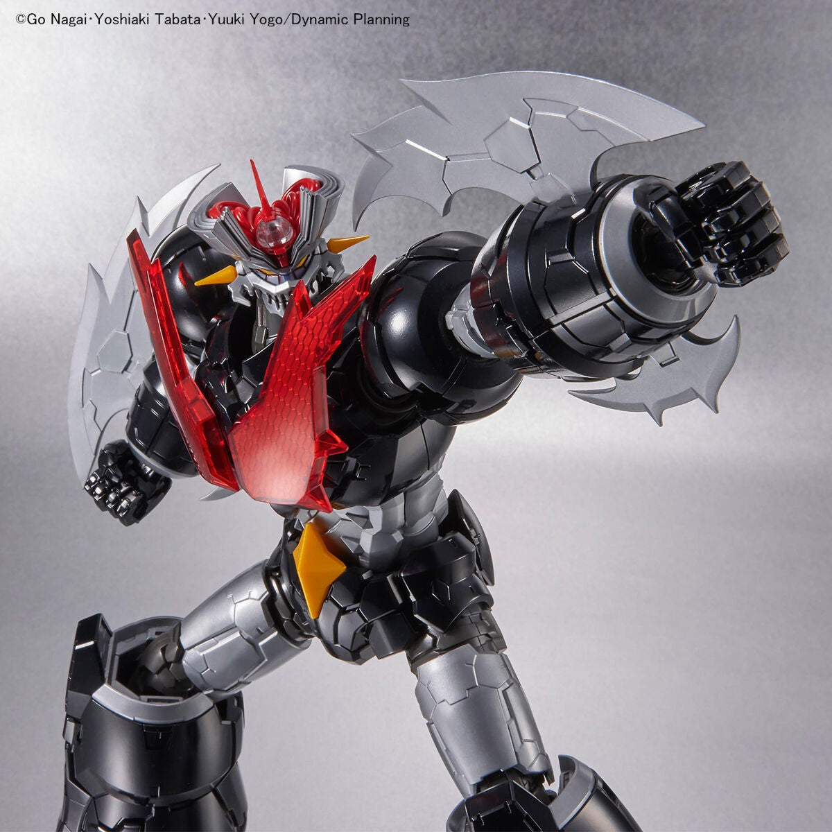 Mazinger ZERO action figure in black and silver with a red chest piece and large axe blades in a dynamic pose.