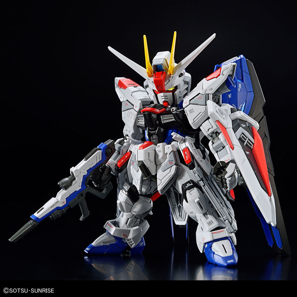 Model kit Bandai MGSD Freedom Gundam: robot assemblato in bianco, blu e rosso con fucile, su sfondo nero.