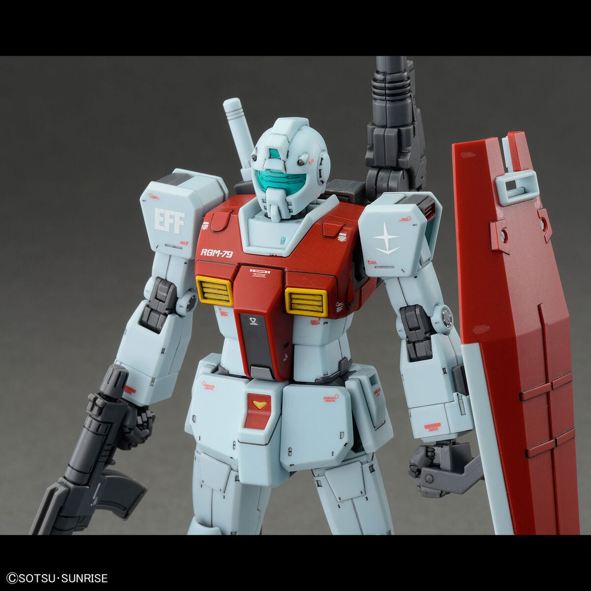 Model kit Bandai HG 1/144 RGM-79 GM con cannone a spalla e scudo, primo piano del robot assemblato.