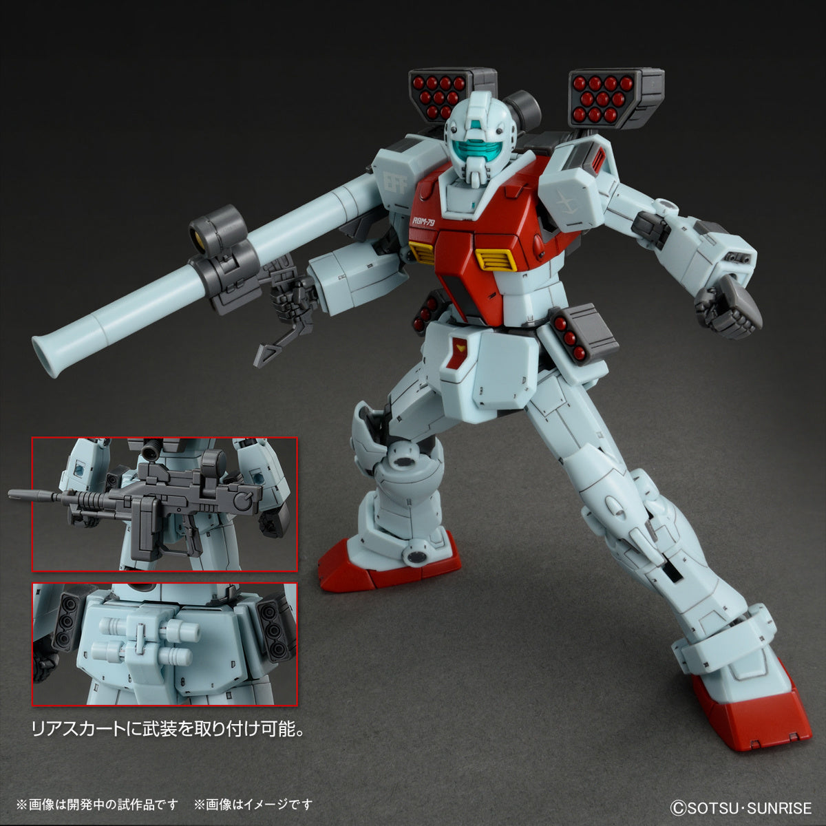 Model kit Bandai HG 1/144 GM con cannoni a spalla, lanciamissili e dettagli delle armi, su sfondo grigio.