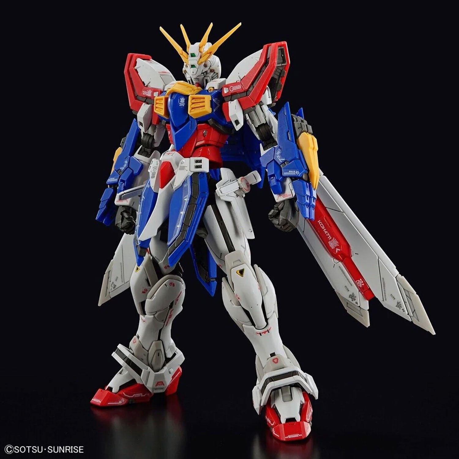 Detailed Gundam model kit with white, blue, and red armor, yellow accents, and wings, isolated on a black background.