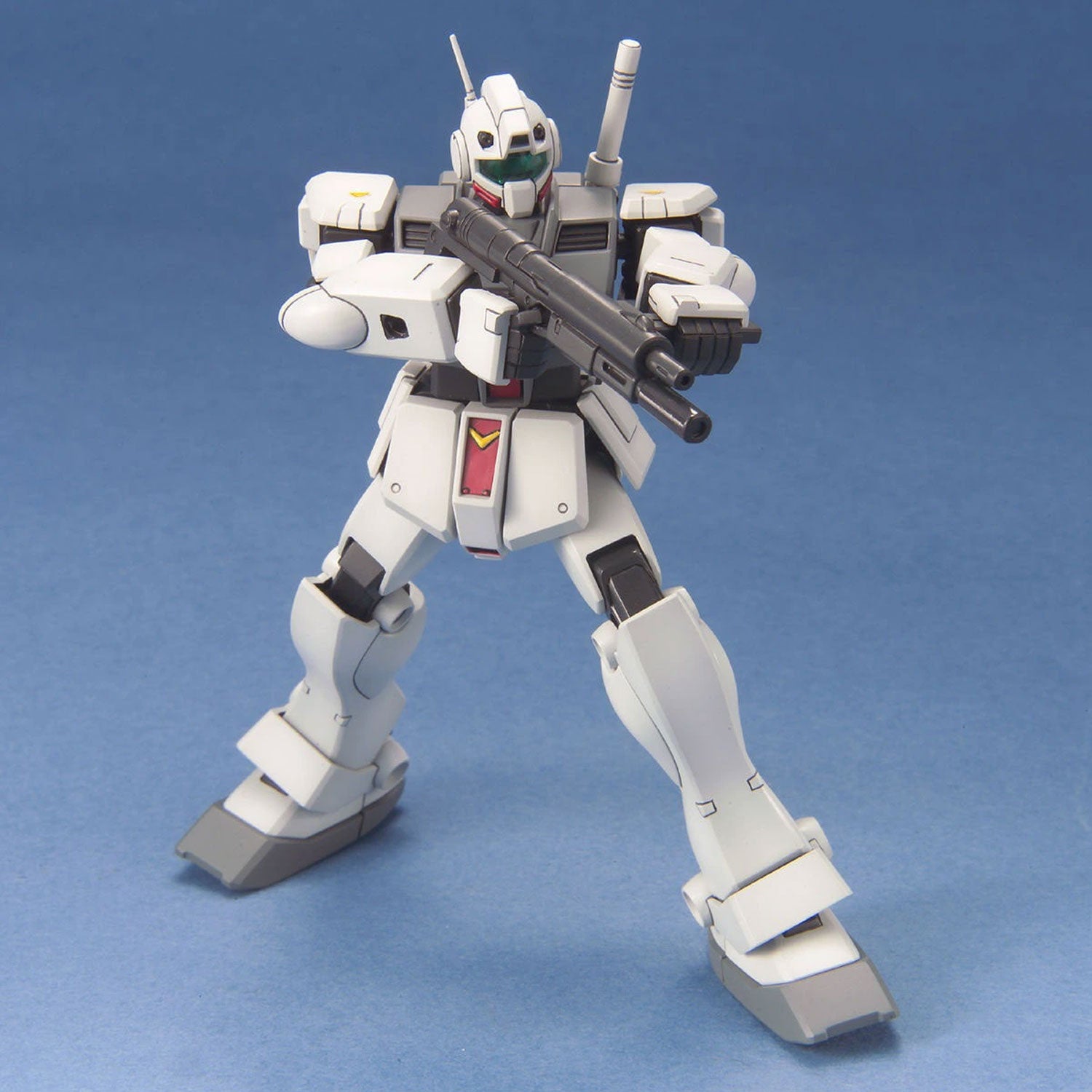 White Gundam model kit action figure holding a gray rifle, posed against a solid blue background.