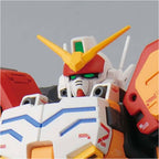 Close-up of a white, red, and yellow Gundam model kit head and torso with green eyes and V-fin crest.
