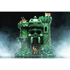 Set costruzioni Mega Construx Castello di Grayskull con action figure di He-Man in primo piano su sfondo nebbioso.