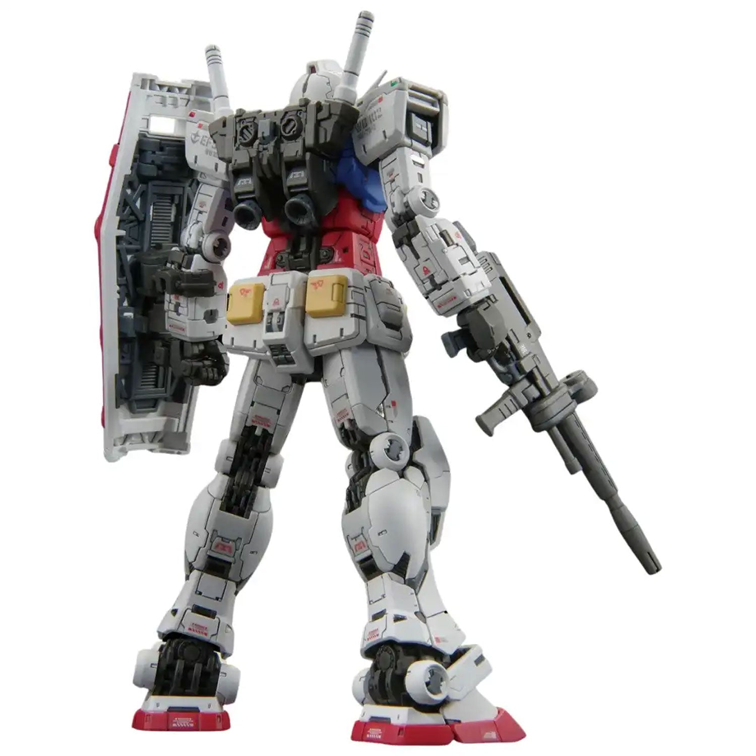 Rear view of a white, red, and blue Gundam model kit holding a rifle and shield, featuring intricate mechanical details.
