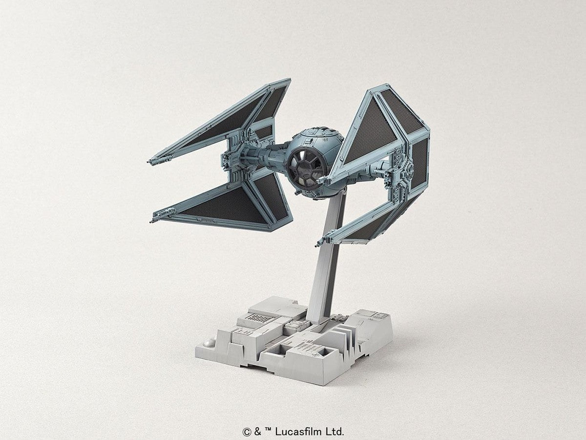 Model kit of a Star Wars TIE Interceptor in light gray, mounted on a detailed display stand against a neutral background.