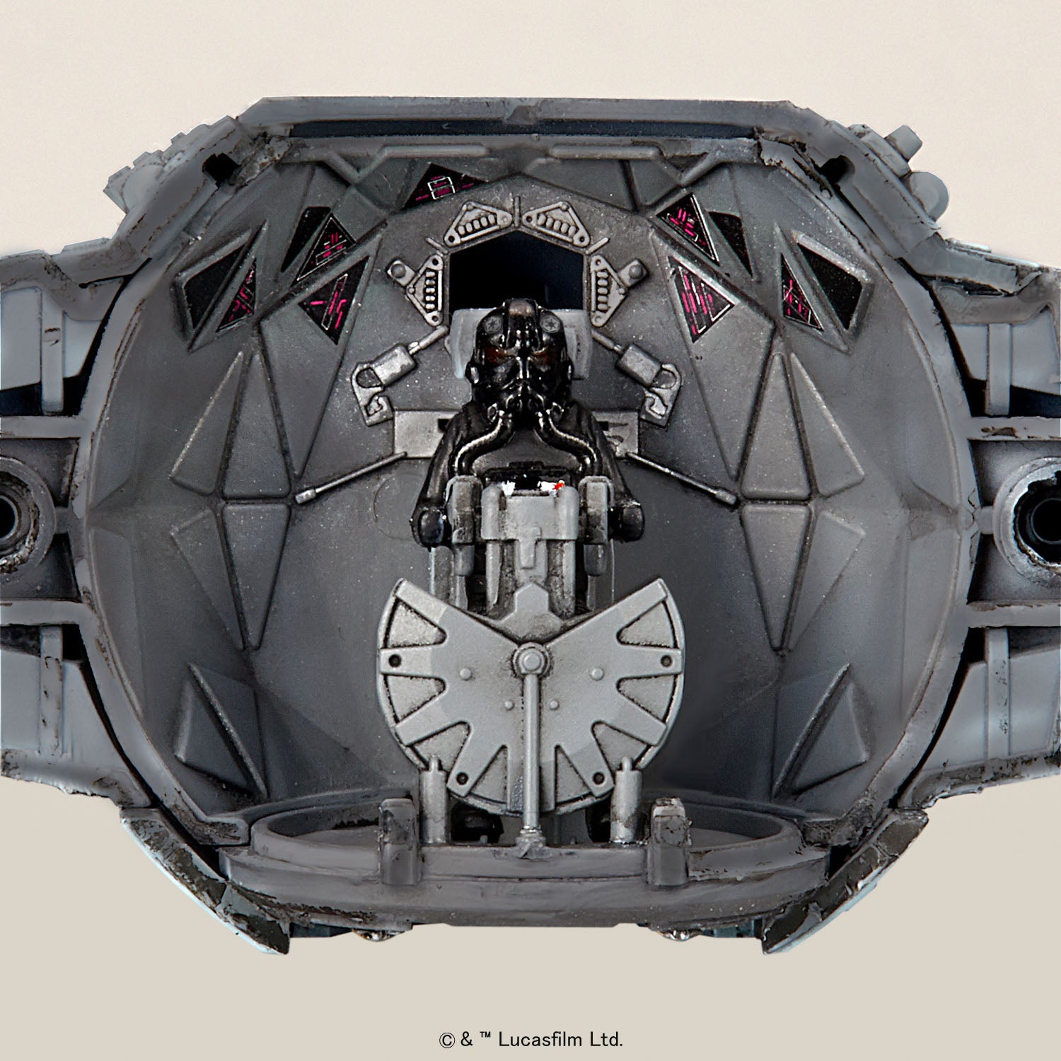 A detailed grey TIE fighter cockpit model with a black pilot figure at the controls.