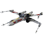 Star Wars X-wing starfighter model with red and yellow markings, open wings, and an R2-D2 unit, isolated on white.